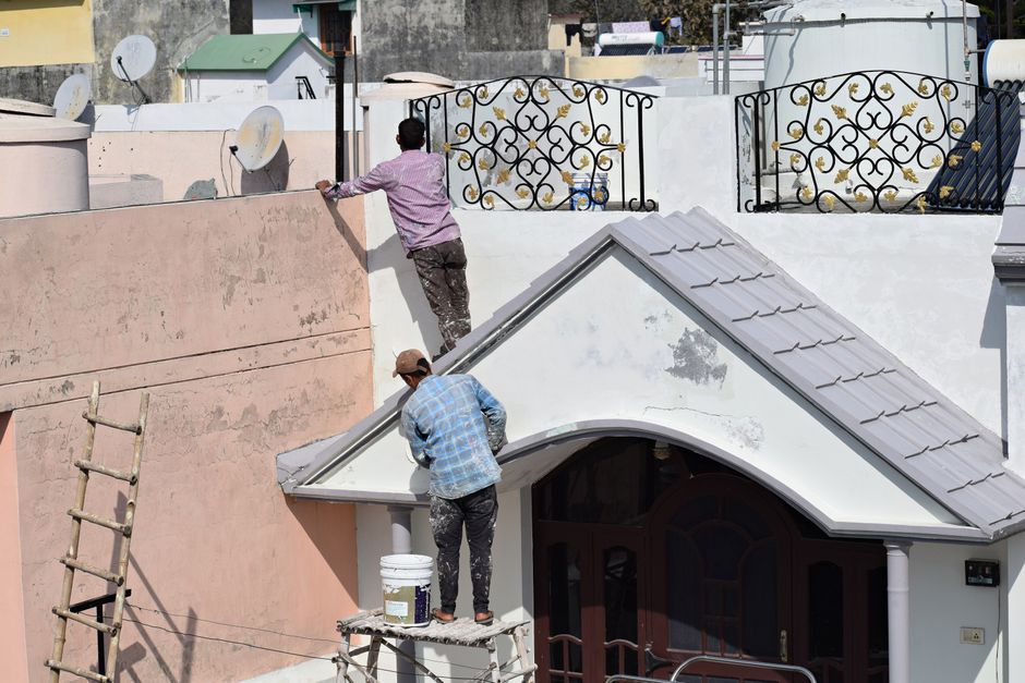 Two painters working on a building exterior.